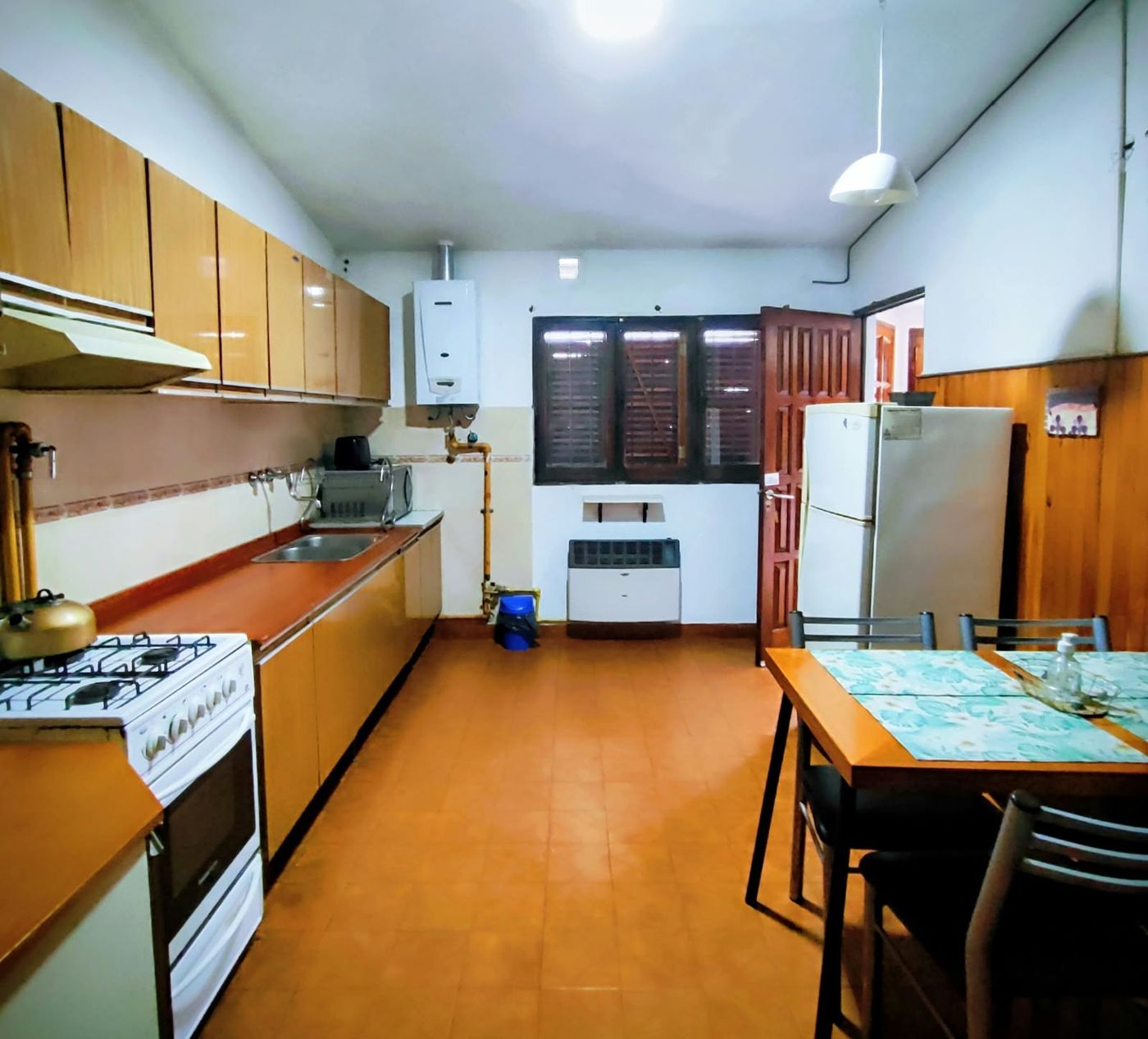 Cocina con horno, heladera y mesa