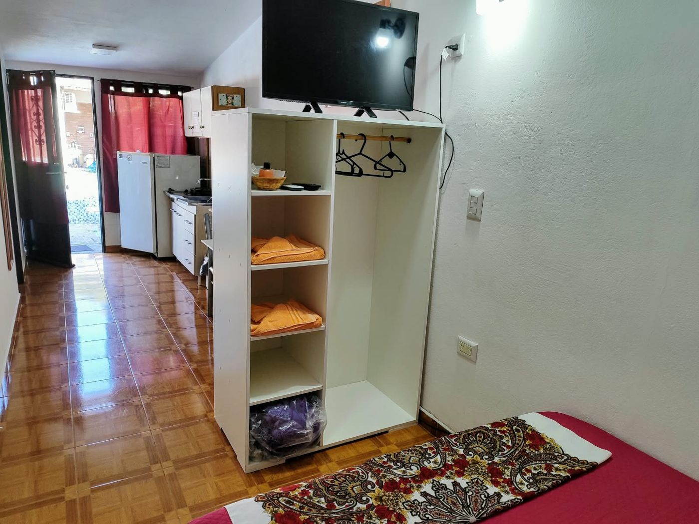 El monoambiente con la tele, el placard y la cama