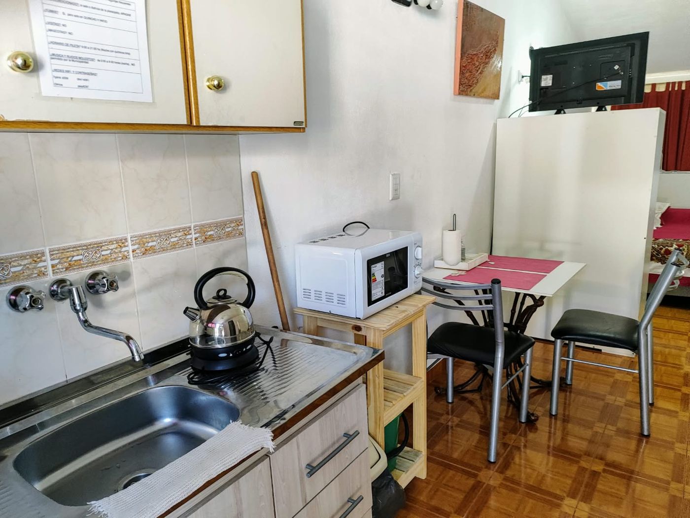 La cocina del monoambiente con mesa para dos